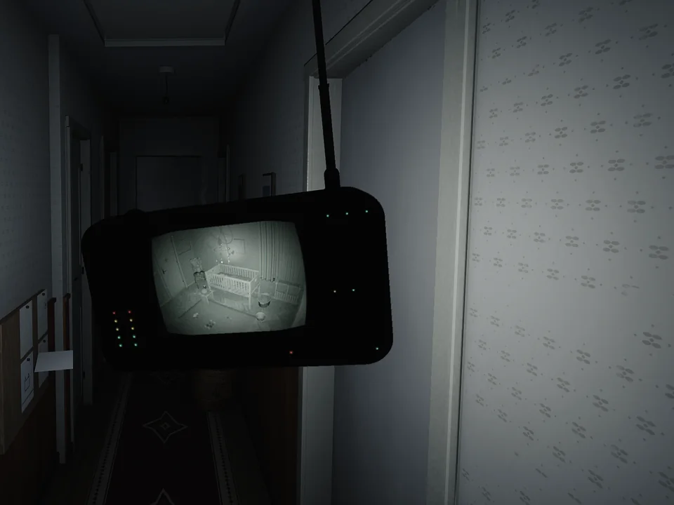 The HUSH-1 baby monitor held up in a dark corridor, its screen showing the crib in infrared.
