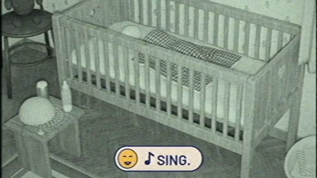 Grainy infrared video of a crib with an on-screen instruction: Sing.