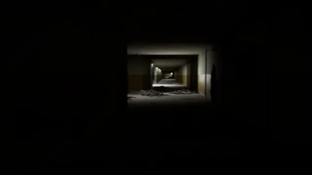 A pitch-black corridor with one small lit doorway far ahead