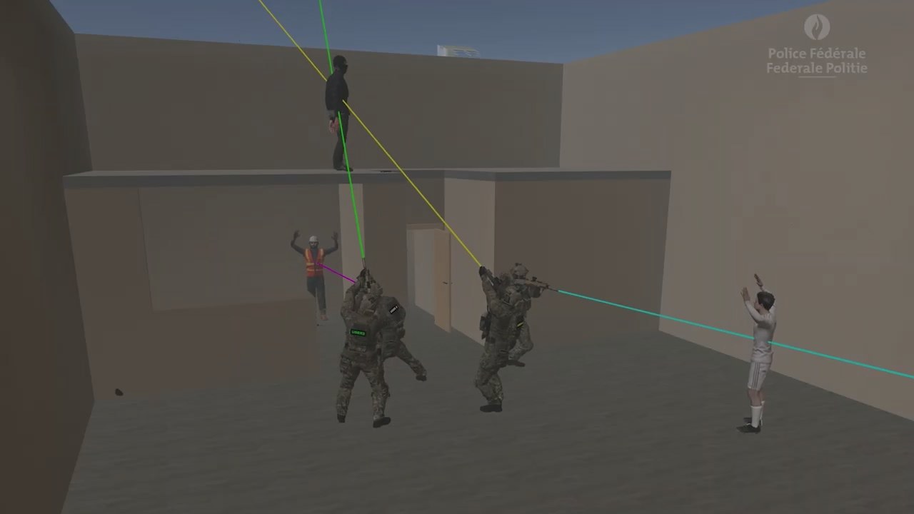 A simulated compound seen from the courtyard: two trainees in the foreground, one figure standing on a roof and another across the yard